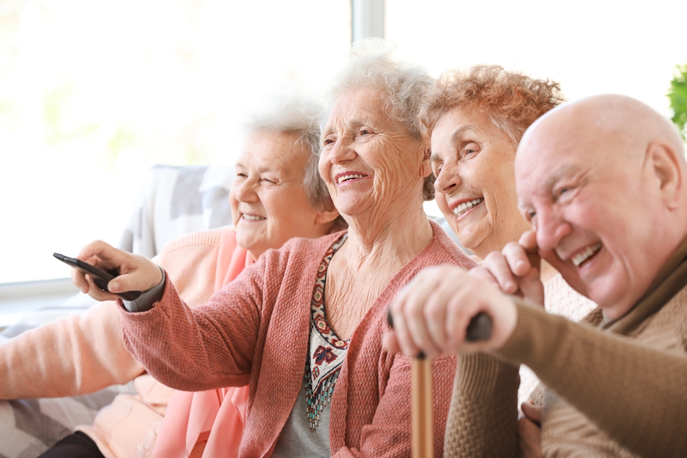 nursing home seniors watch tv in a group